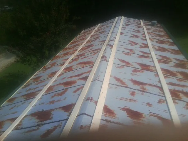 Rusted metal roof panels with new wood purlins before replacement — Storm Damage Roof Repair in Munford by Roofing Brothers