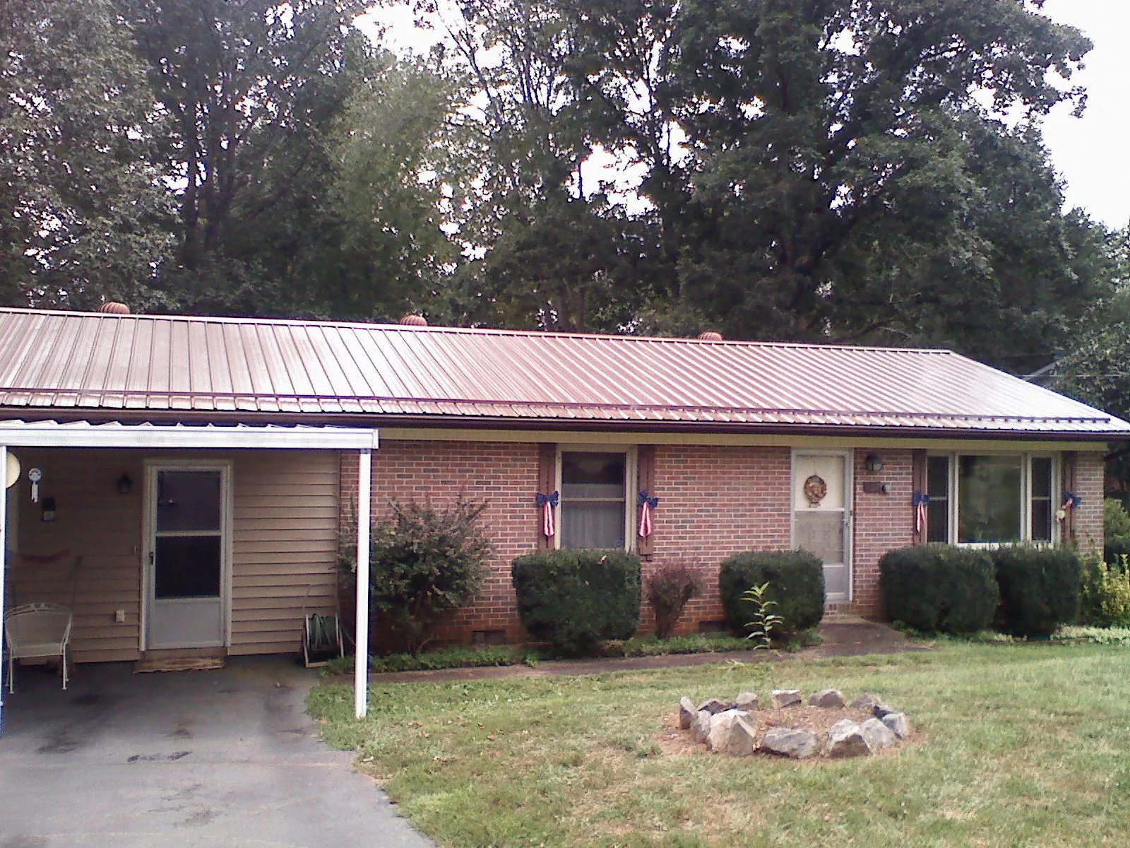 Bronze metal roof and carport on a brick ranch home — Roof Repair work by our crew in Munford